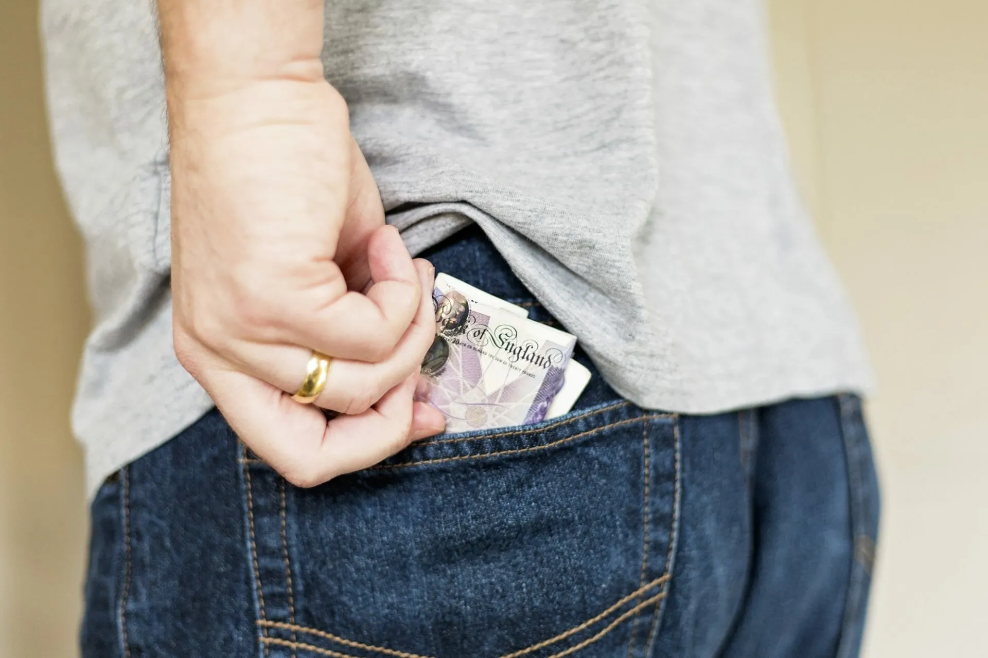 tradesman with cash in his hand putting it in his back pocket