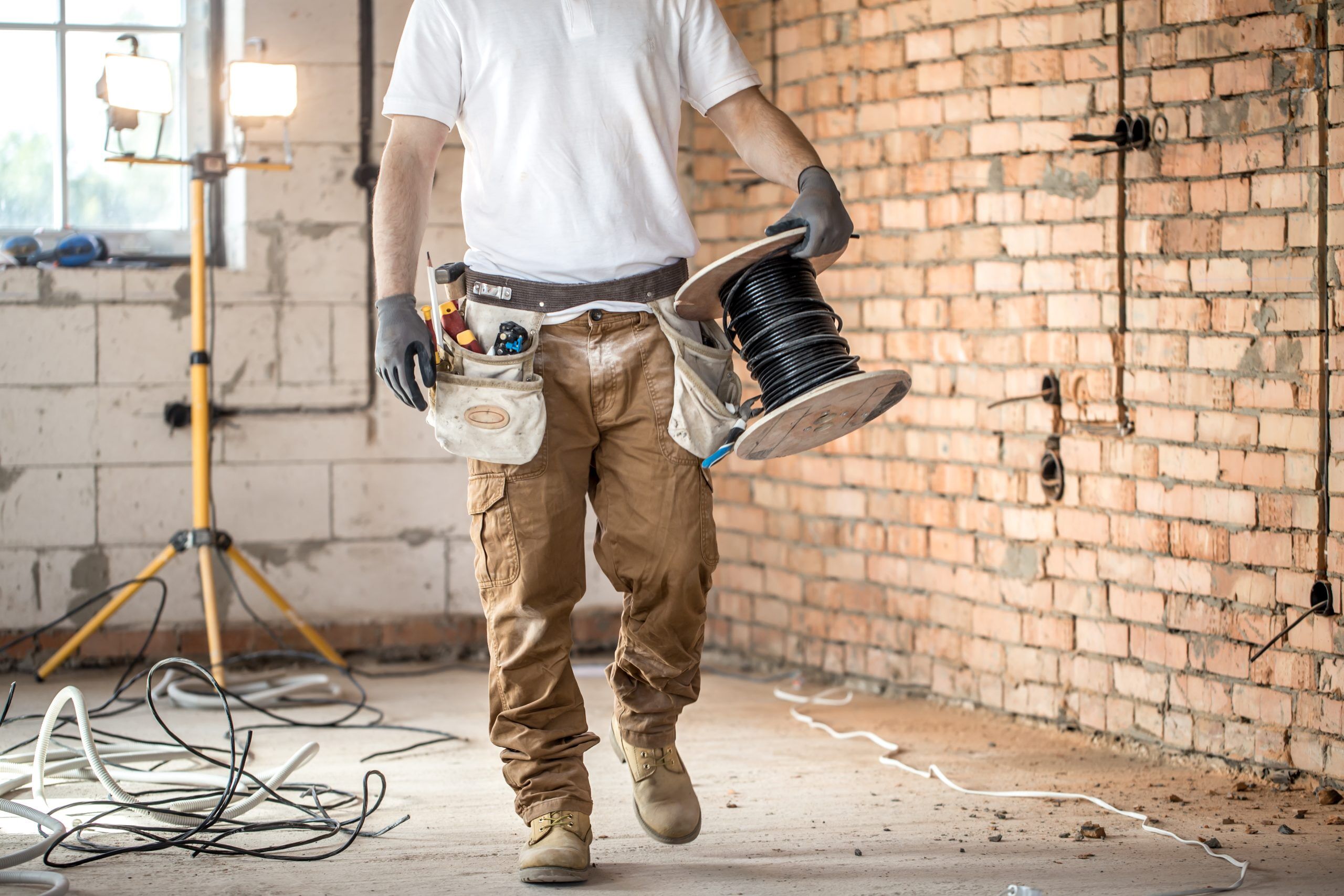 electrician-with-tools-working-construction-site-repair-handyman-concept-scaled